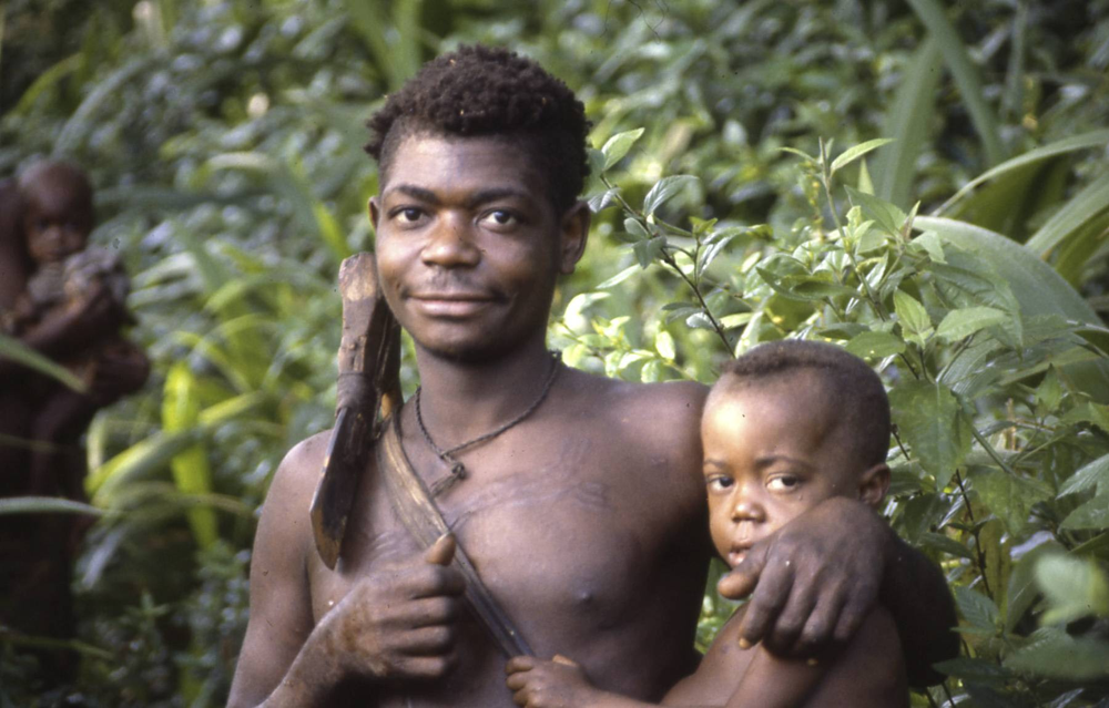 An Aka father from Central Africa holds his young son. Among the Aka, fathers are famously hands-on, spending nearly half the day within arm’s reach of their infants. This high involvement of fathers and other community members reflects a cooperative breeding system thought to resemble that of early humans.